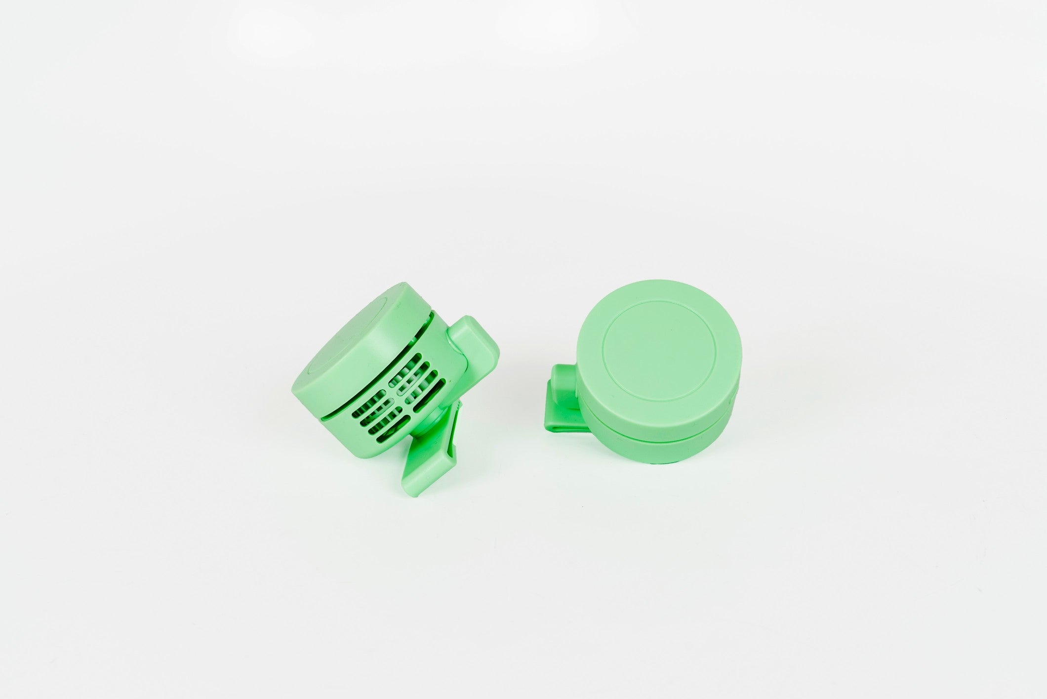 A pair of light mint green plastic fans.