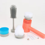 A portable handheld electric cleaning brush set on a white background, featuring a coral orange body, white bristles, a gray handle, a gray bottle-cleaning brush, a blue sponge, and a white charging cable.
